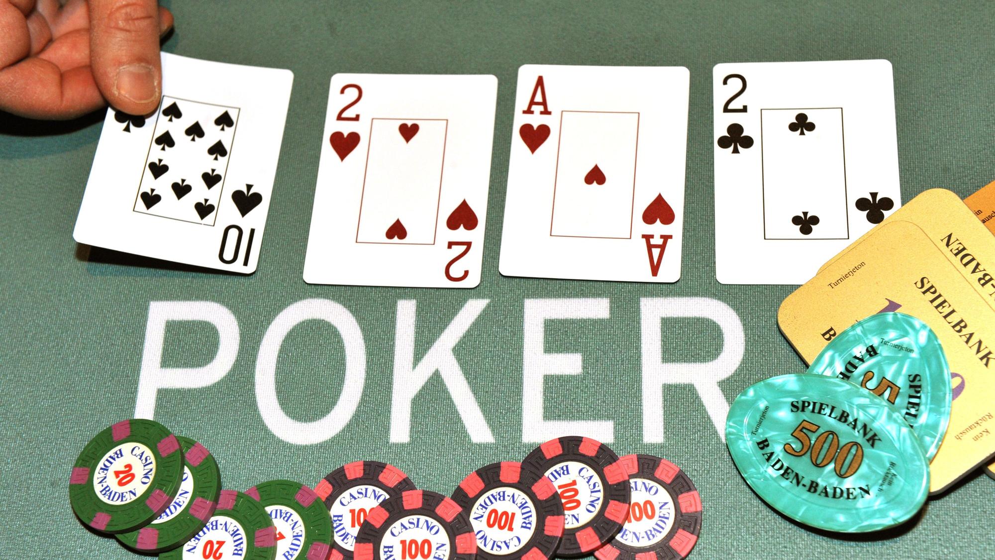 Ein Dealer legt bei einem Pokerspiel die Pokerkarten auf den Tisch.
