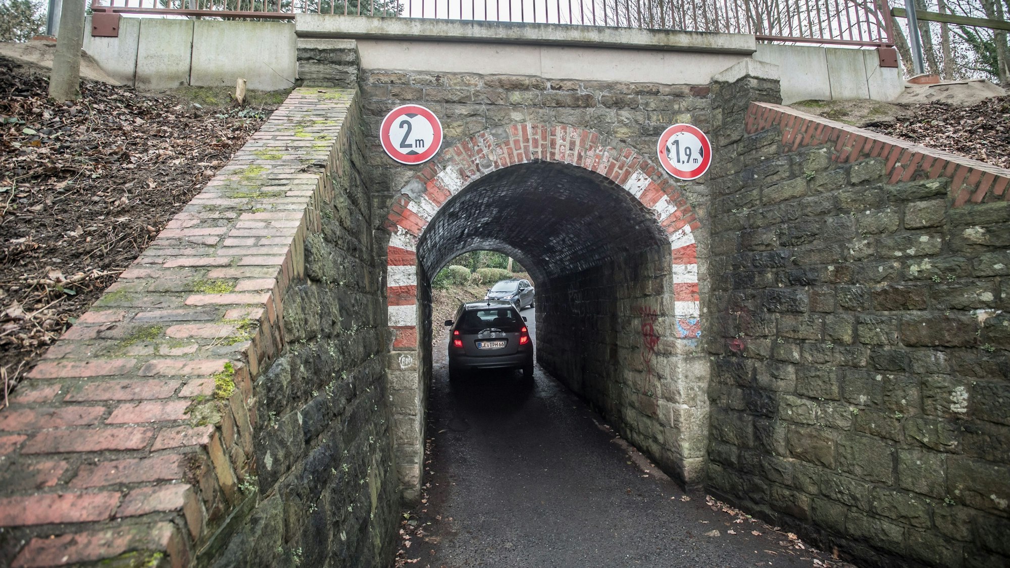 Ein Auto fährt auf der Neukronenberger Straße durch den Tunnel unter der Balkan-Express-Strecke.