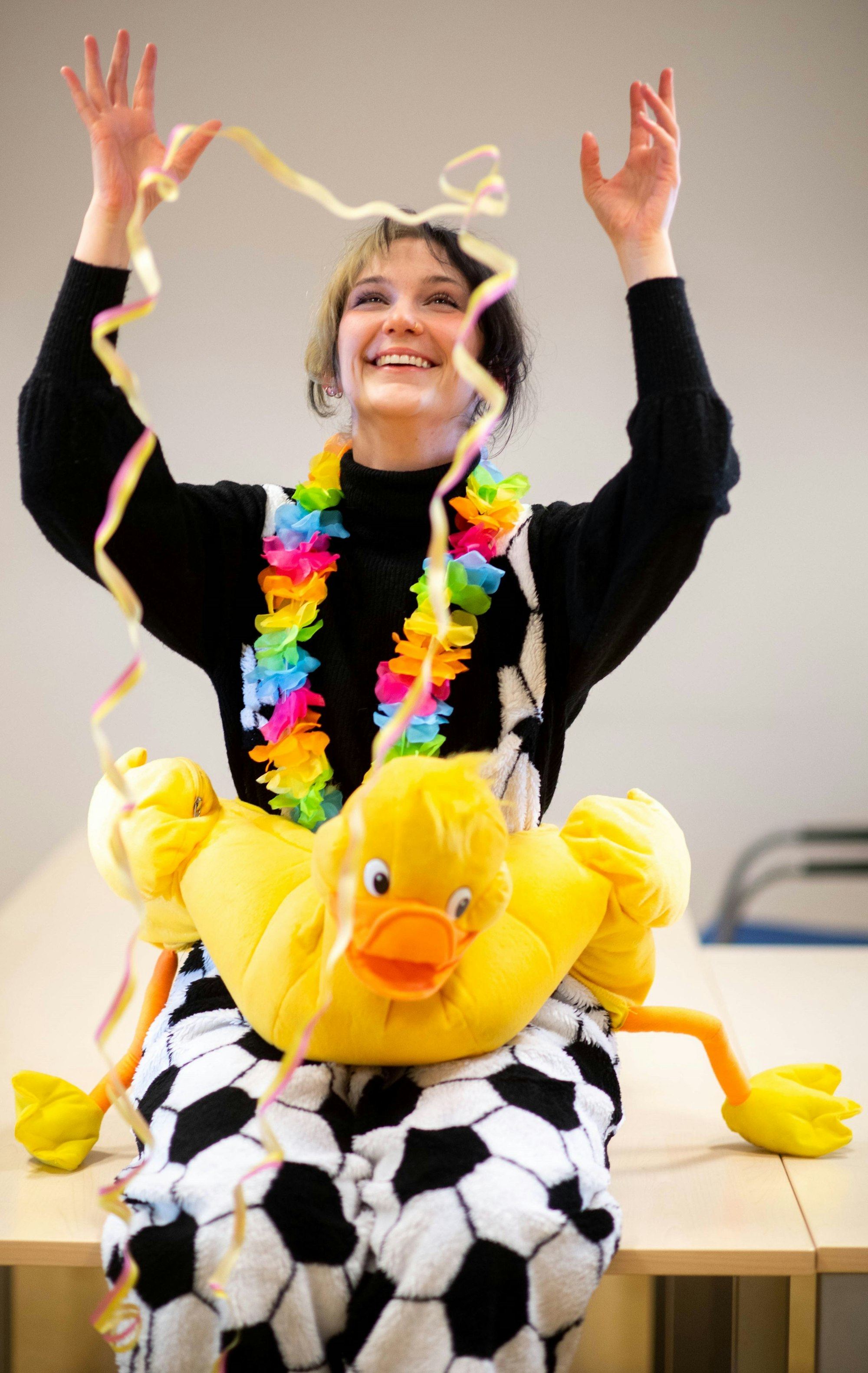 Voluntärin Elena Pintus sitzt jeck verkleidet auf einem Tisch