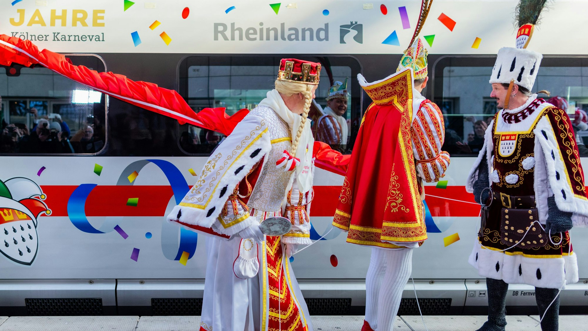 Das Kölner Dreigestirn vor einem karnevalistisch dekorierten ICE