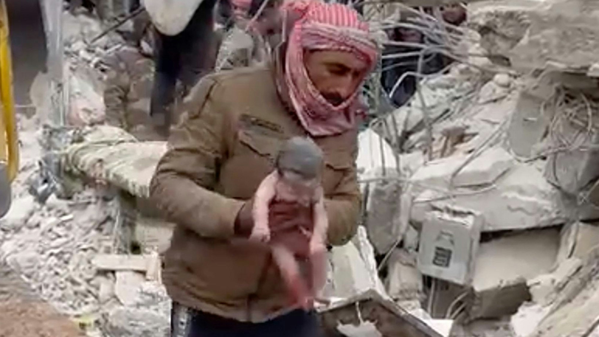 08.02.2023, Syrien, Jinderis: Ein Retter trägt ein neugeborenes Mädchen, nachdem er es aus Trümmern befreit hat. Bewohner der nordwestsyrischen Stadt entdeckten das schreiende Kind, dessen Mutter es unter den Trümmern eines fünfstöckigen Wohnhauses, das durch das verheerende Erdbeben zerstört wurde, geboren hatte, wie Verwandte und ein Arzt berichten (bestmögliche Qualität). Foto: Uncredited/Verified UGC/AP/dpa +++ dpa-Bildfunk +++