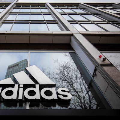 Das Adidas-Logo am Eingang eines Geschäfts.