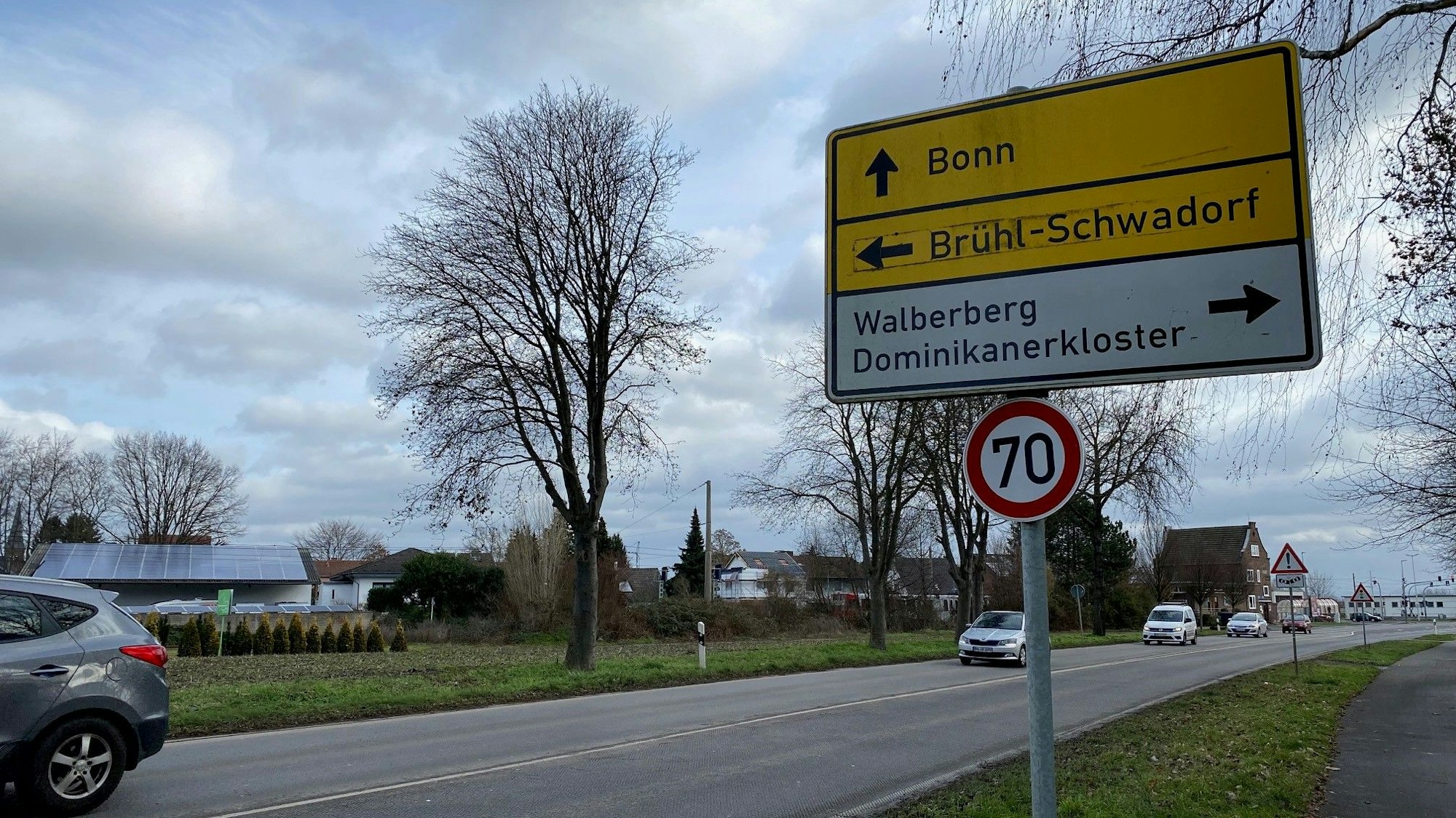 Es ist eine Straße mit einem Schild zu sehen, auf dem Brühl-Schwadorf als Richtung angegeben ist.
