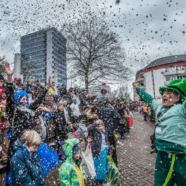 Eine verkleidete Frau wirft auf dem Wiesdorfer Karnevalszug Konfetti.