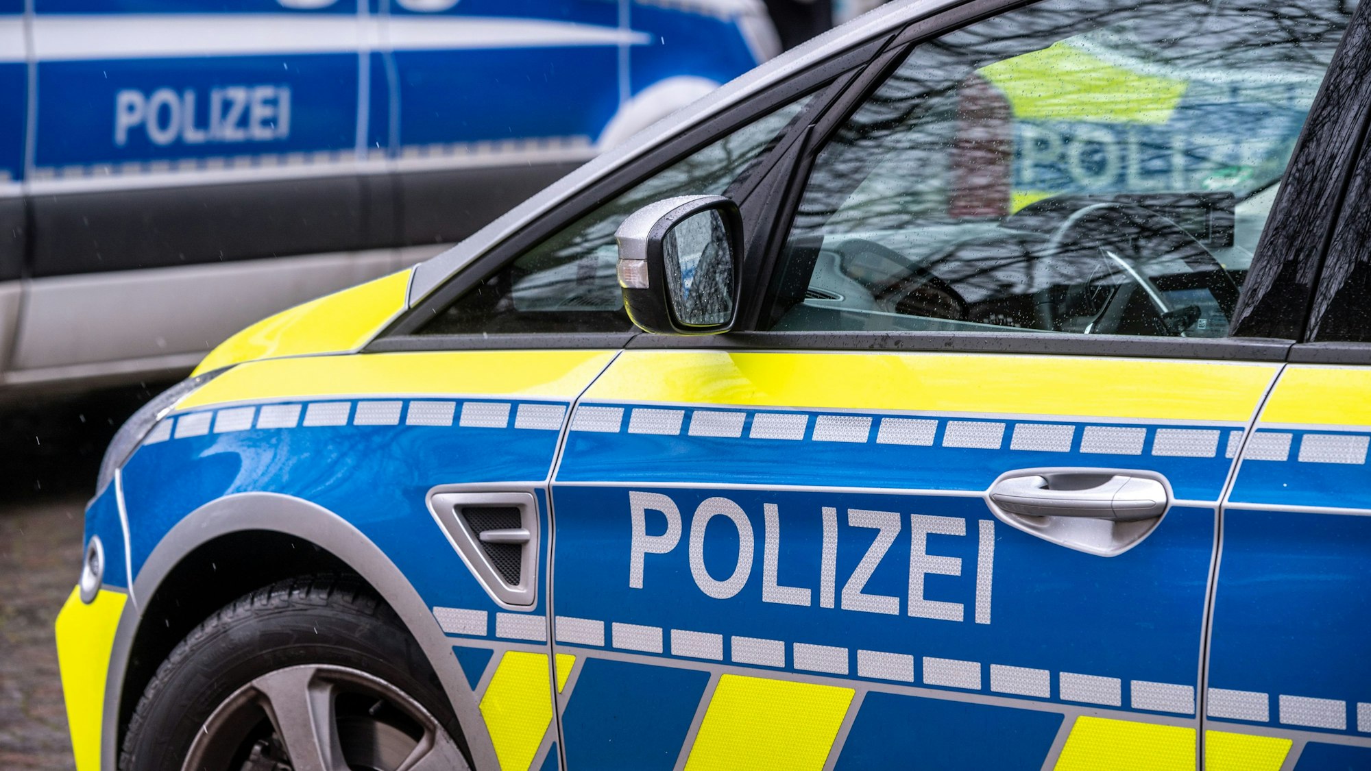 Zwei Polizeifahrzeuge stehen voreinander.