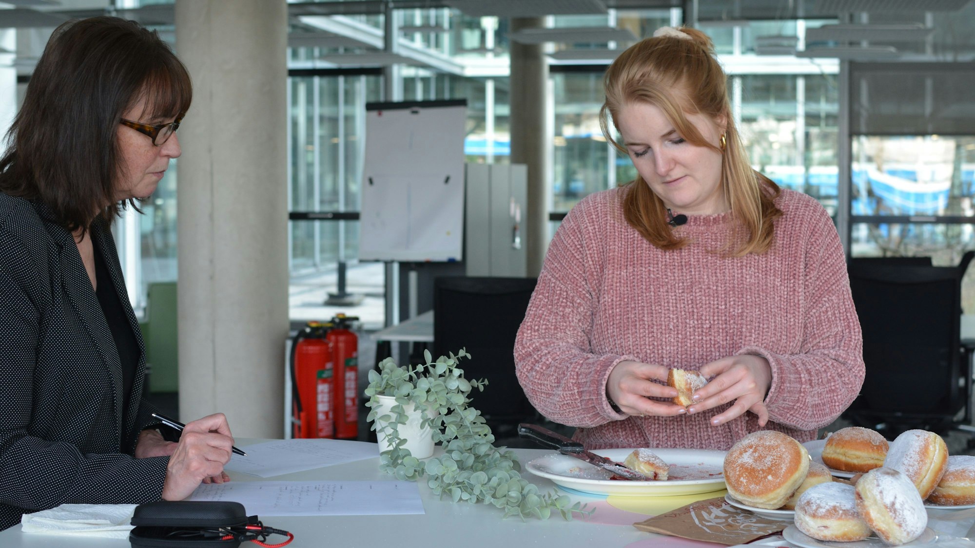Zwei Frauen am Tisch, darauf liegen Berliner.