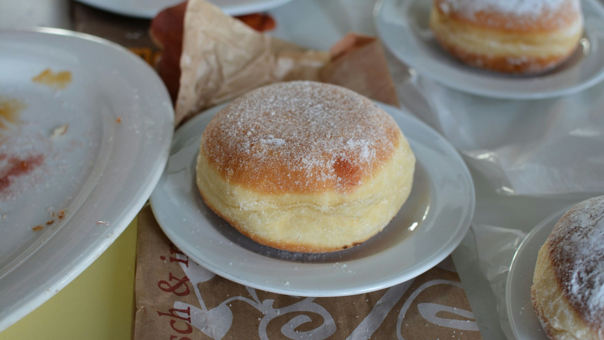 Ein großer Berliner auf einem Teller.