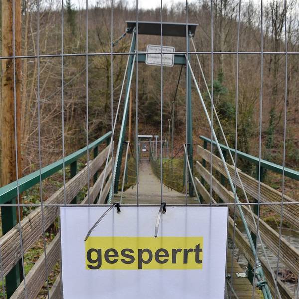 Es ist die abgesperrte Brücke mit einem Schild auf dem „gesperrt “ steht zu sehen.