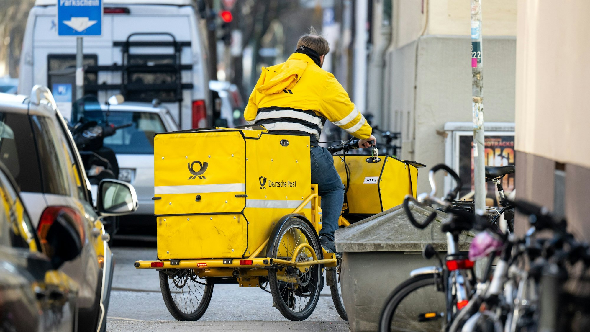Ein Briefträger fährt mit seinem Fahrrad eine Straße entlang. Die Tarifverhandlungen für die Beschäftigten der Deutschen Post sind gescheitert.