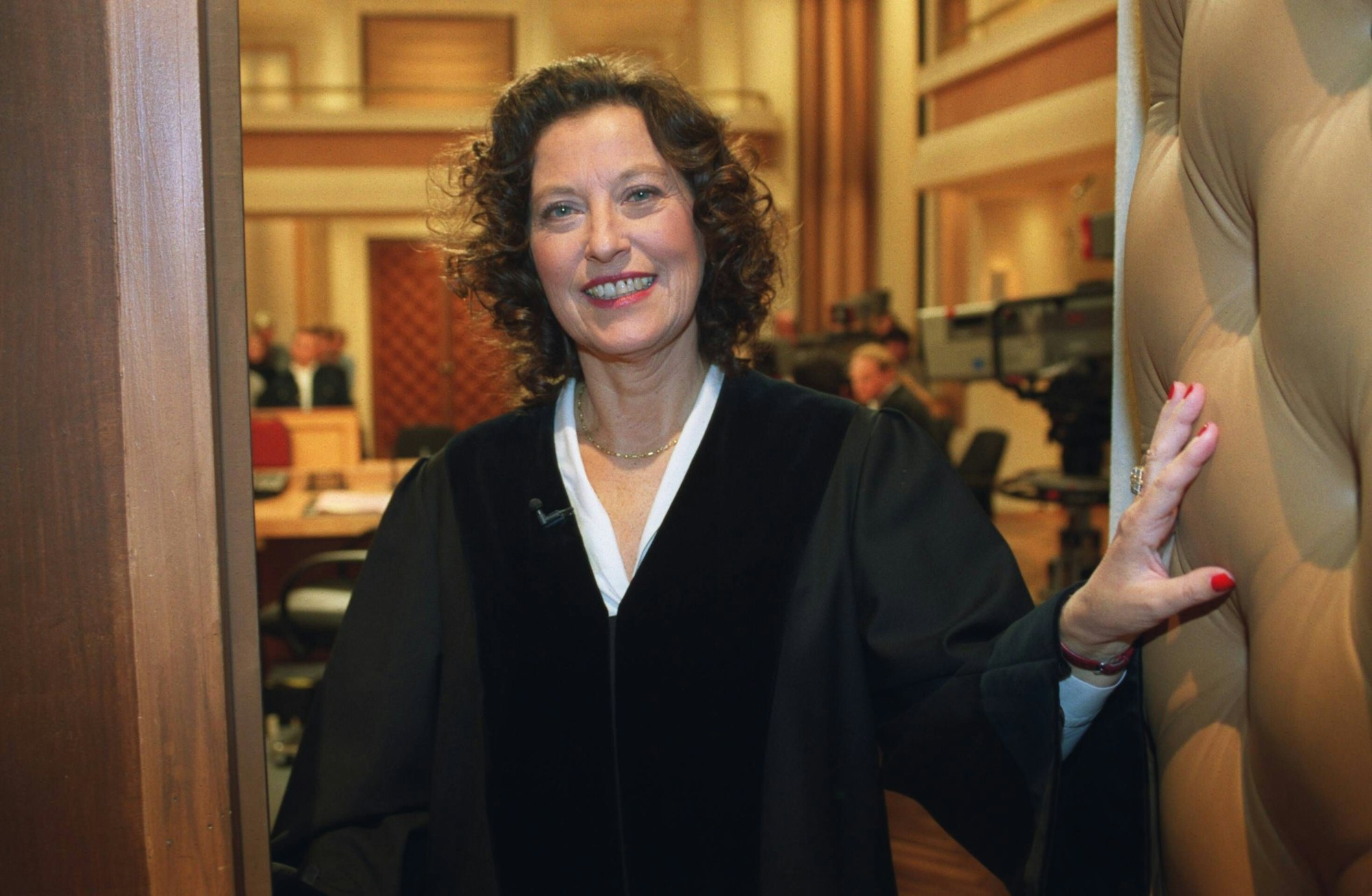 Ruth Herz steht in schwarzer Richterrobe vor einem Gerichtssaal