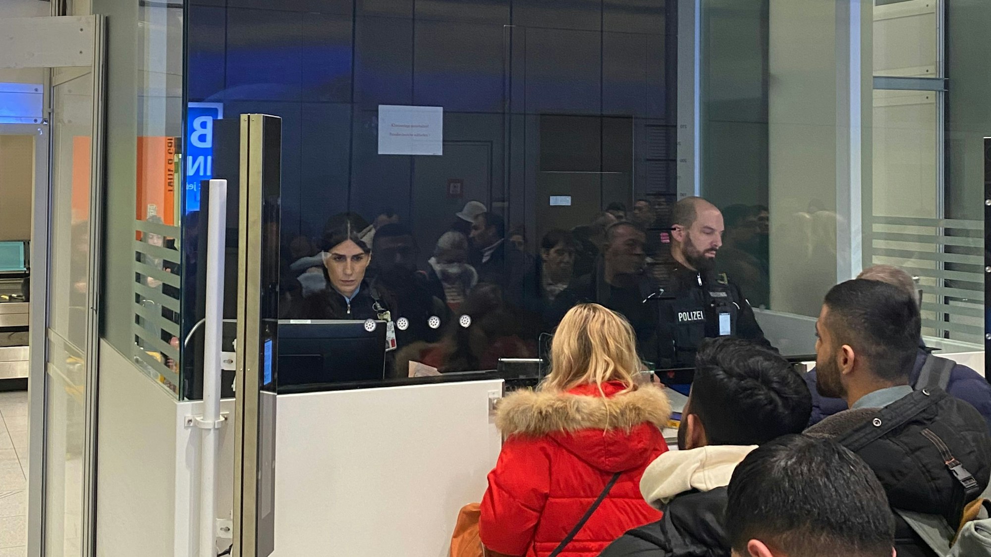 Die Bundespolizisten Yagmur Özkaya und Marc Schmelzer sitzen in einer Box der Passkontrolle am Flughafen Köln-Bonn und kontrollieren die Ausweise von Passagieren aus Istanbul.