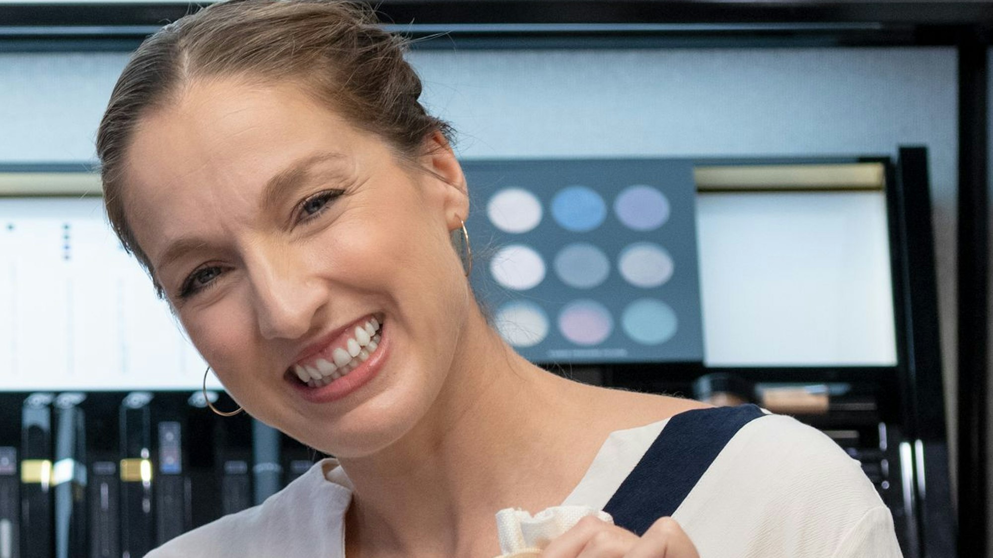 Die Inhaberin der Parfümerie Möltgen, Ariane Brendel-Möltgen, präsentiert den Beauty-Benefizkalender zugunsten von wir helfen.