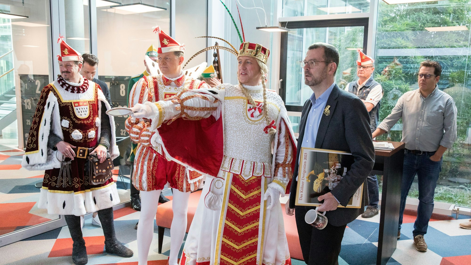 Das designierte Kölner Dreigestirn der Session 2023, Bauer Marco (Marco Schneefeld), Prinz Boris I. (Boris Müller), und Jungfrau Agrippina (André Fahnenbruck, v.l.) mit Chefredakteur Carsten Fiedler.