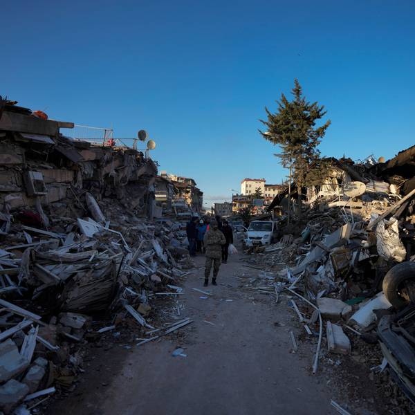 Ein Mann geht inmitten zerstörter Gebäude. In den Erdbeben-Gebieten in Syrien und der Türkei werden bei der Suche nach Verschütteten immer mehr Leichen aus den Resten eingestürzter Gebäude geborgen.