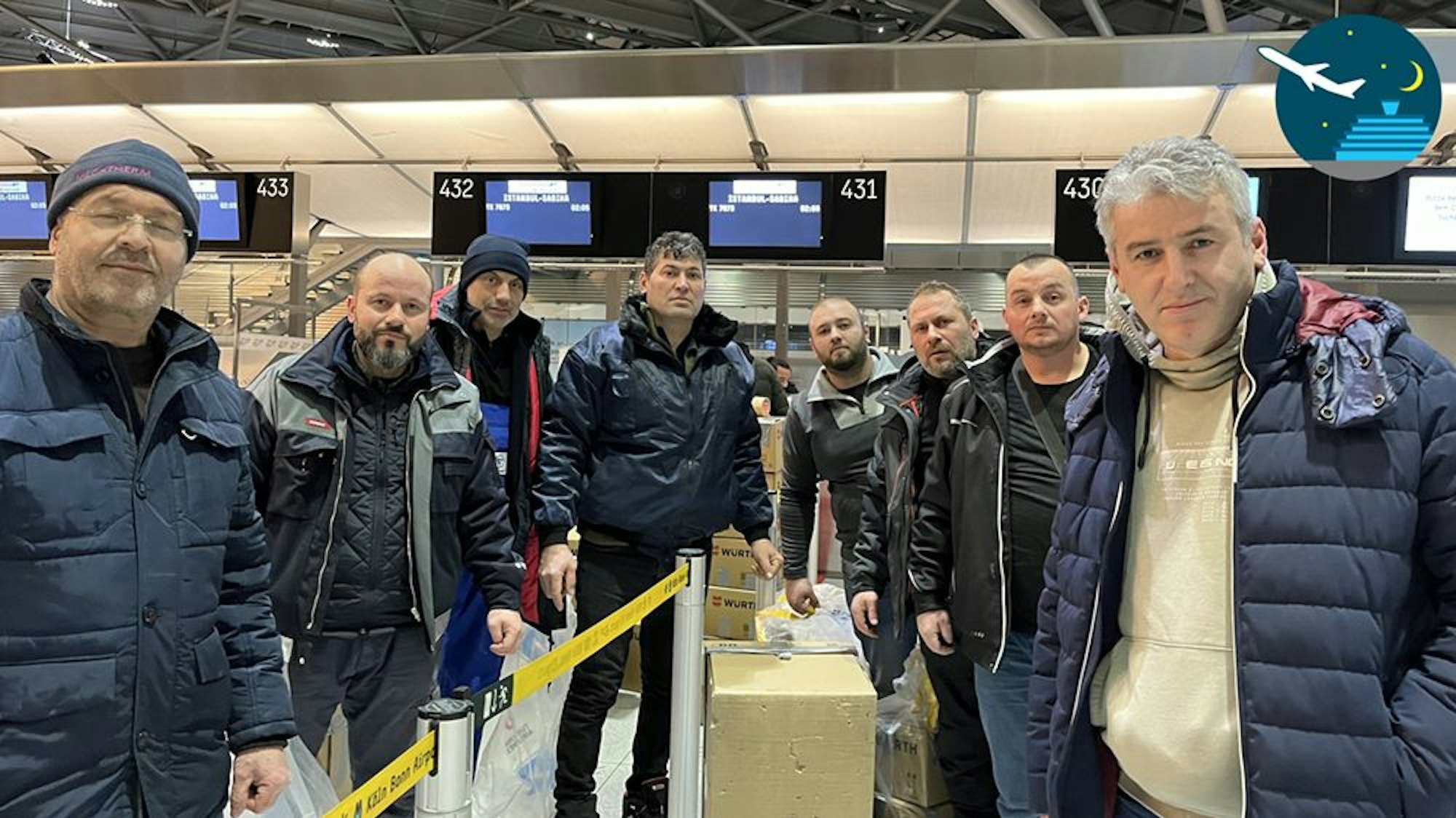 Eine Gruppe mit acht Helfern steht vor dem Abflug ins Erdbebengebiet am Terminal 2 am Flughafen Köln/Bonn.