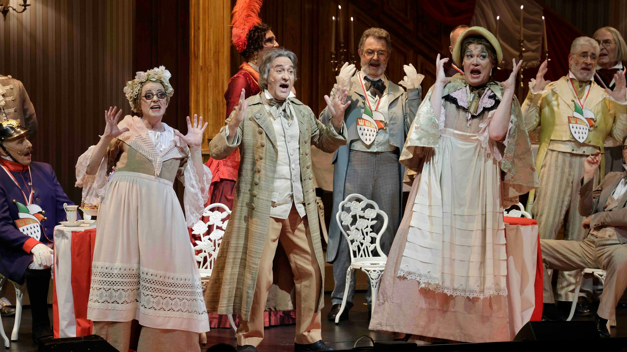 Schauspielerinnen und Schauspieler schauen erschrocken und heben die Hände in die Luft.