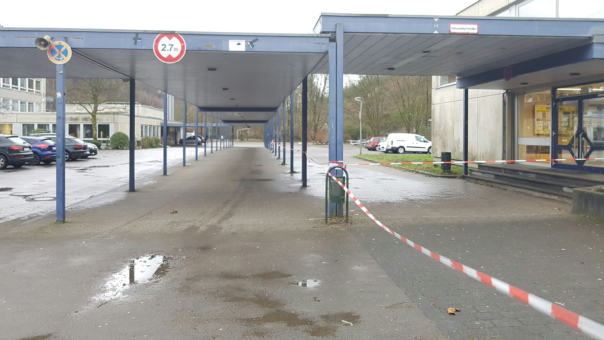 Blick auf ein Schulzentrum. Ein Absperrband flattert zwischen den Laubengängen. (Symbolbild)