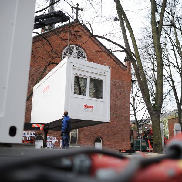 Ein Container hängt an einem Kram und wird abgesetzt.