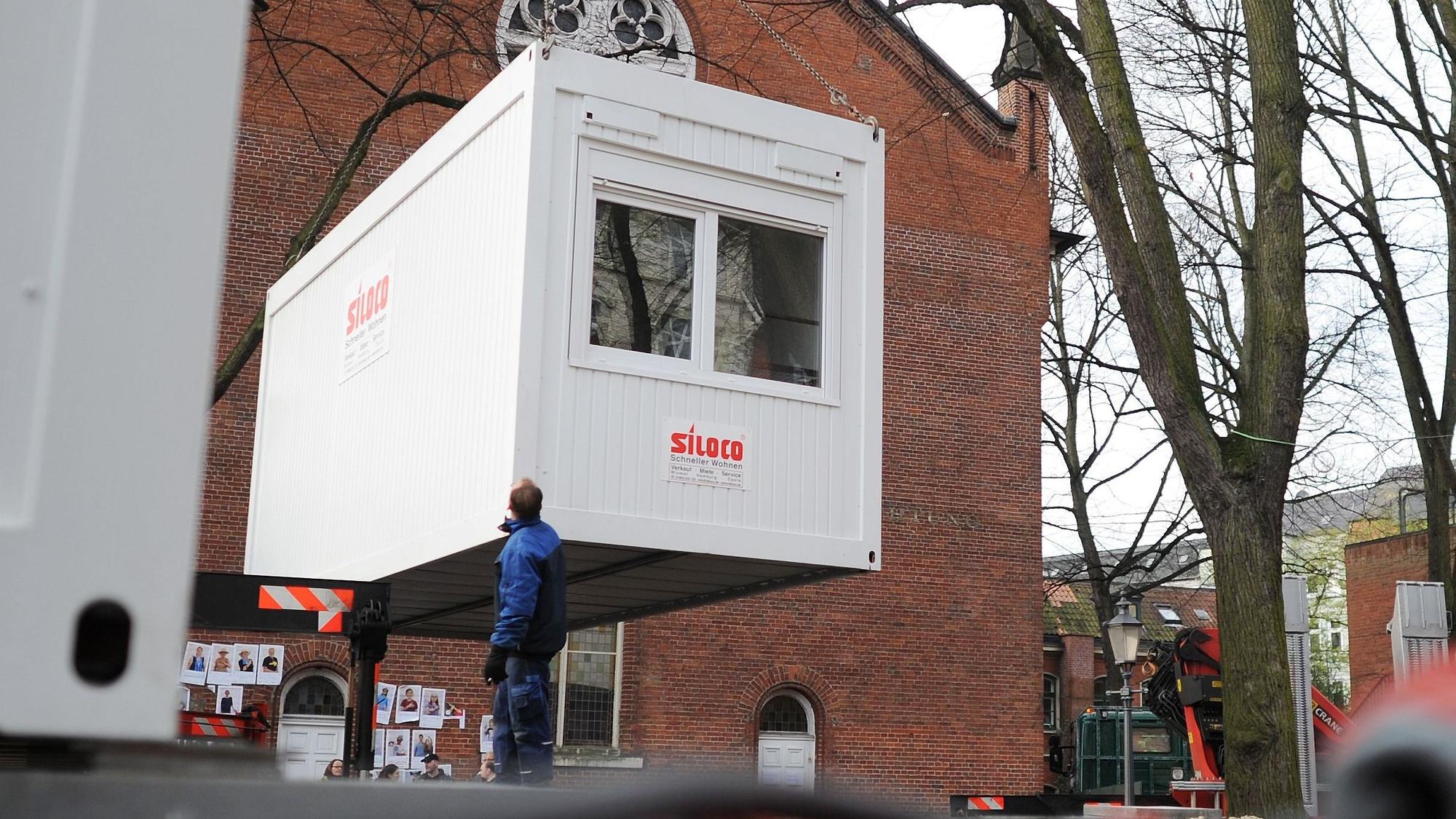 Ein Container hängt an einem Kram und wird abgesetzt.
