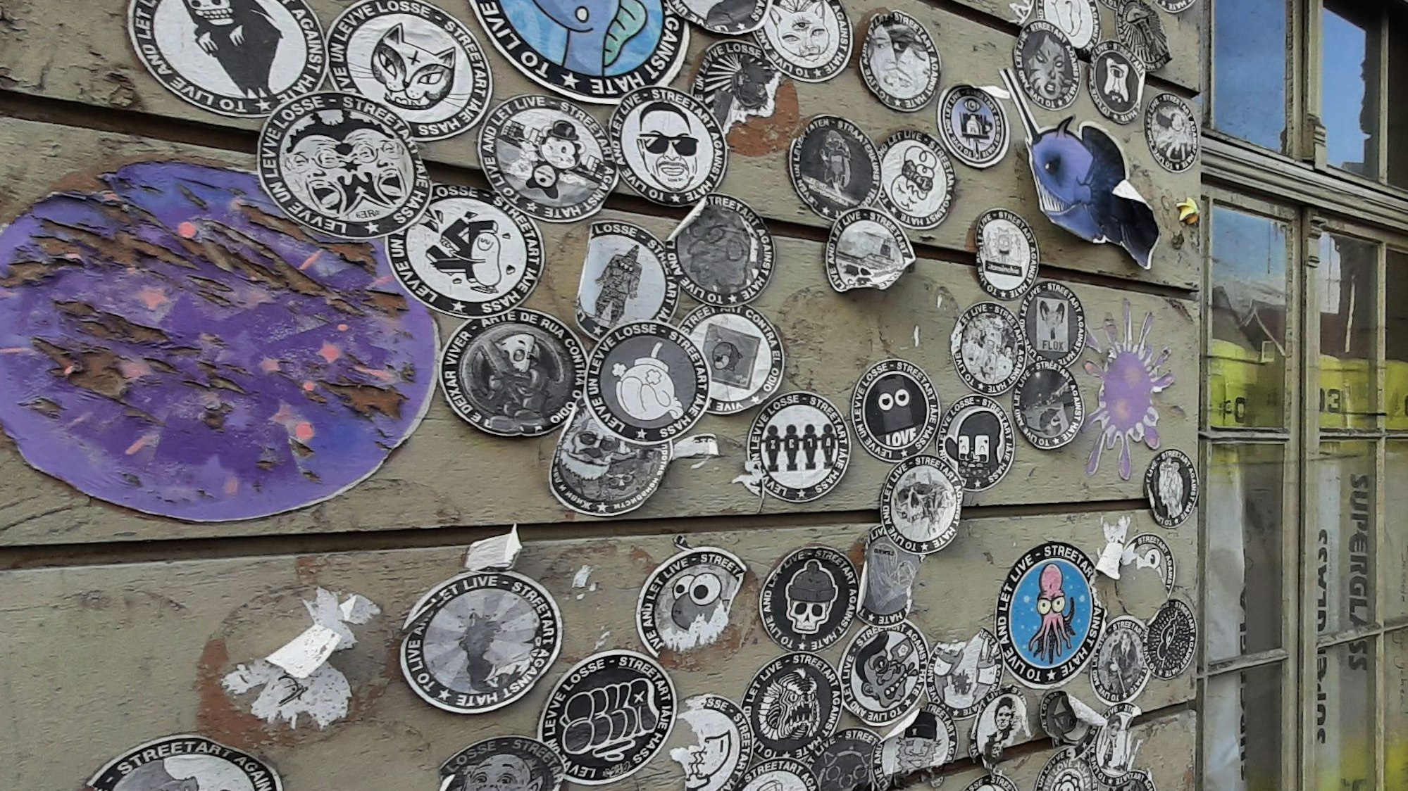 Hauswand an der Münzstraße mit von Künstlern aus aller Welt stammenden Street-Art-Stickern der Aktion "Street Art Against Hate".