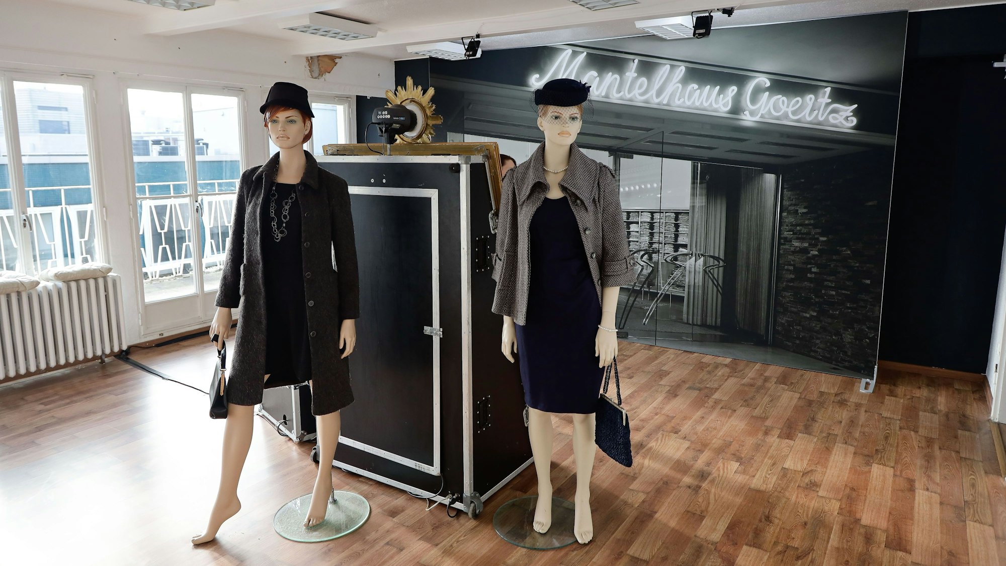 Schaufensterpuppen stehen vor einem Foto mit dem Schriftzug des Mantelhauses Goertz.