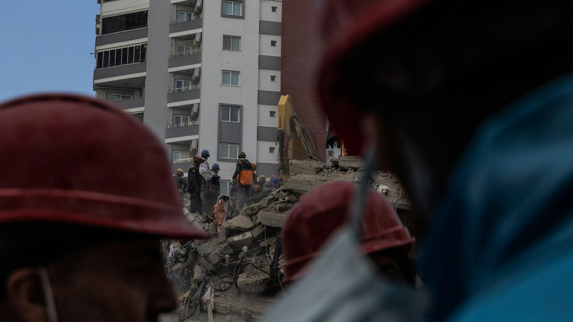Trümmer nach dem Erdbeben. Helfer mit roten Helmen sind vor Ort (Symbolbild)