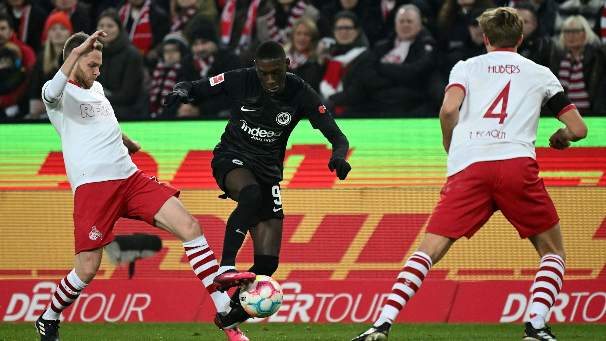 Kolo Muani dribbelt zwischen Schmitz und Hübers
