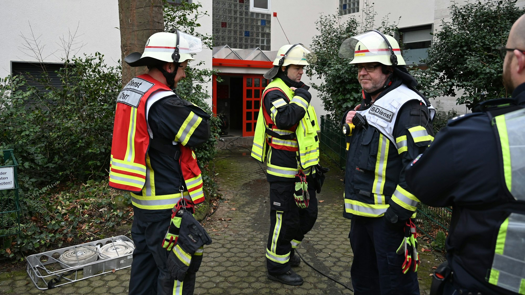 Man sieht Einsatzkräfte vor einem Haus stehen.