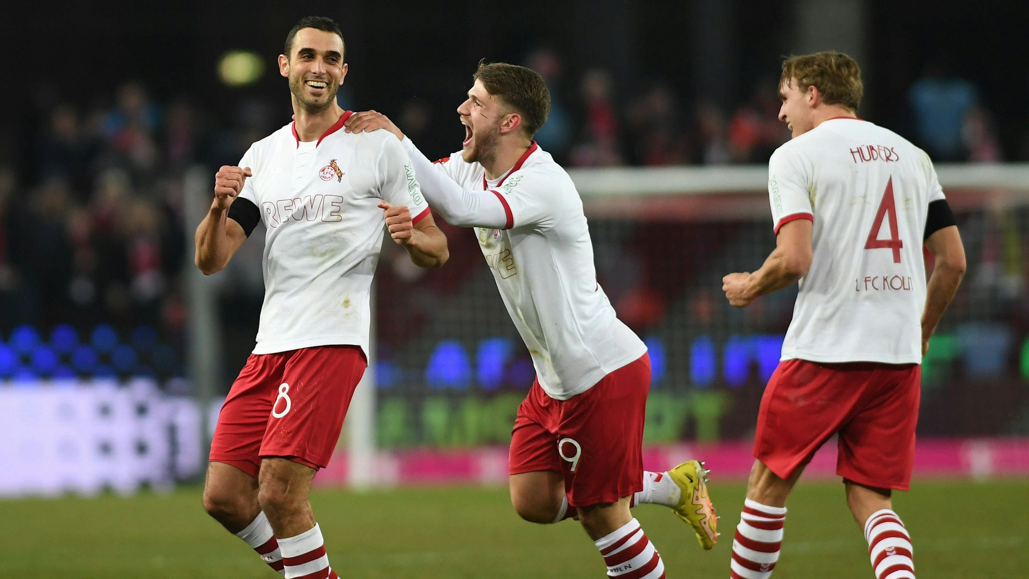 Jubel beim 1. FC Köln: Jan Thielmann (m.) und Benjamin Hübers (r.) feiern Torschützen Ellyes Skhiri.