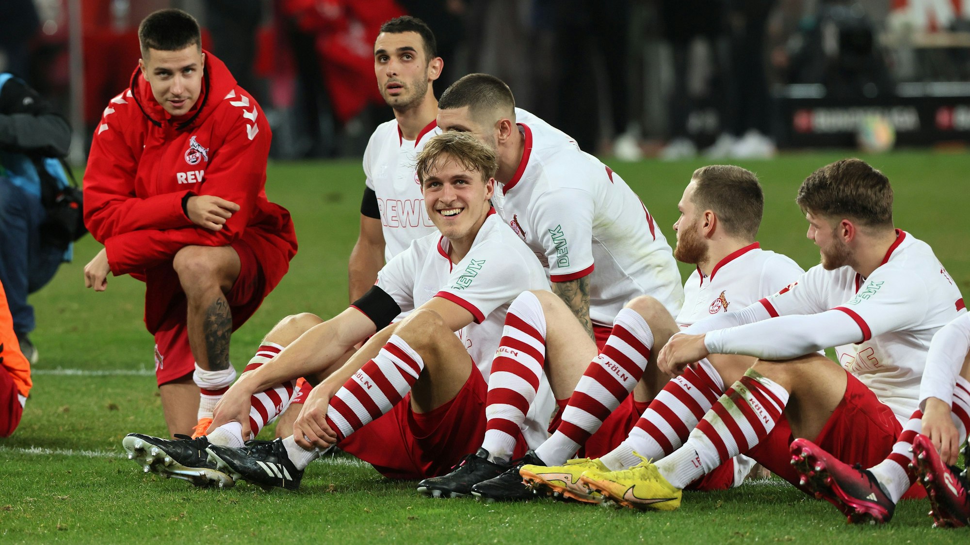 FC-Profis sitzen vor den Fans und genießen den Beifall nach dem Sieg gegen Frankfurt.