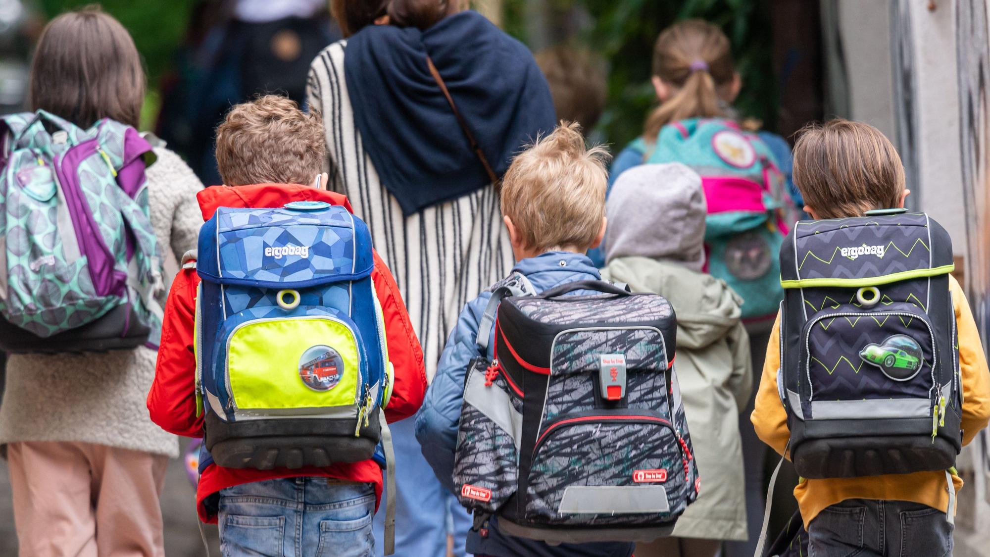 Schulkinder gehen in die Schule.