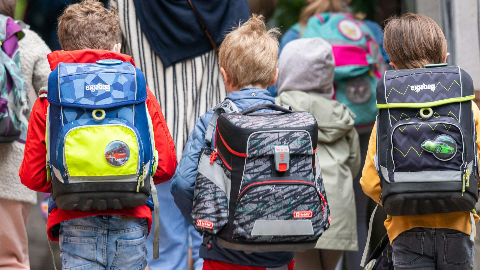 Erstklässler von hinten mit ihren Ranzen.