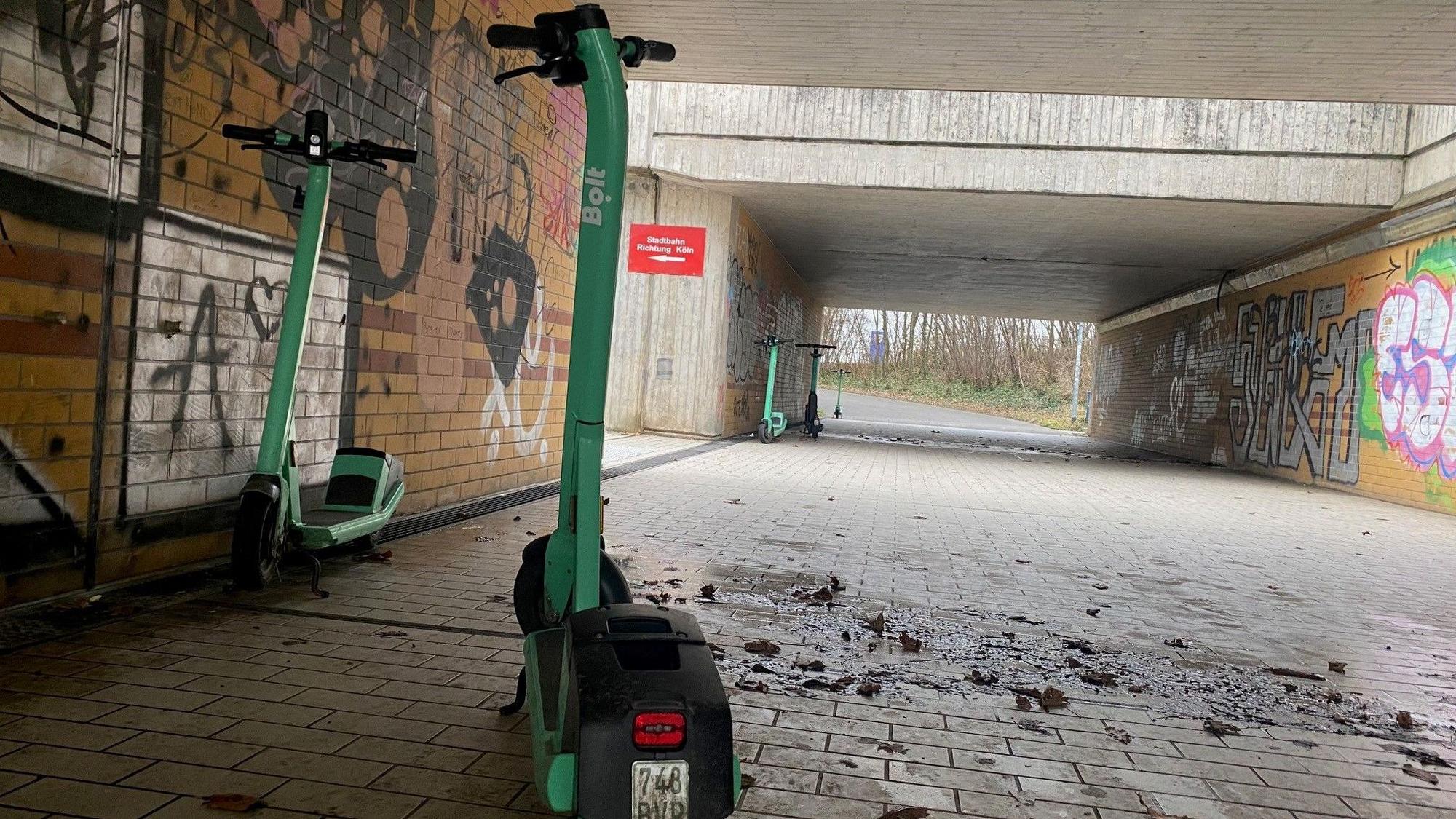 In einer Unterführung stehen mehrere Leih-E-Scooter.