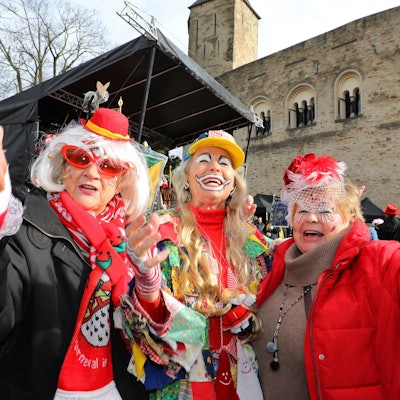 Drei geschminkte Damen jubeln beim Rathaussturm in Bergisch Gladbach in die Kamera.