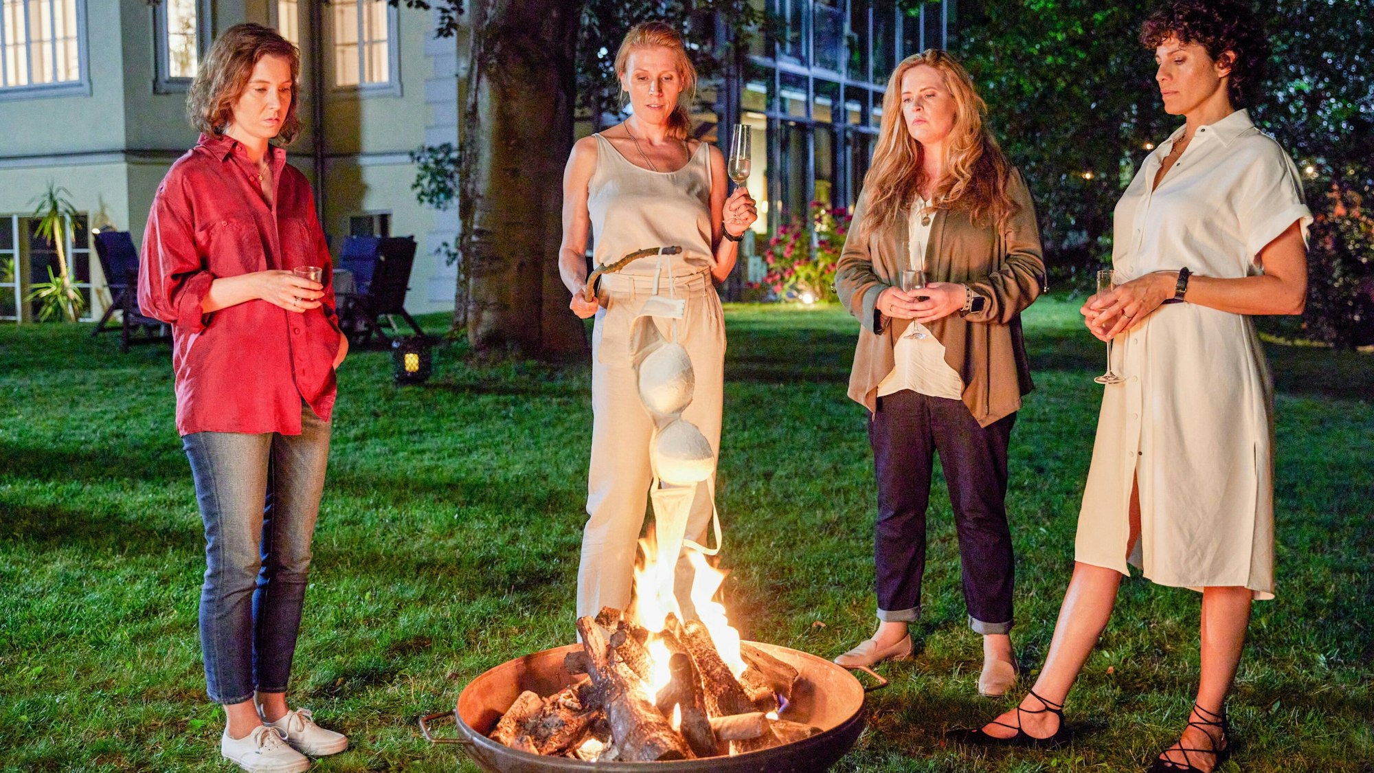 Christiane Boj (Franziska Hackl), Miriam Hintz (Franziska Weisz), Doris Hauke (Diana Amft) und Inès Lemarchal (Jasmin Gerat) stehen im Garten vor einer Feuerschale.
