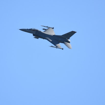 Ein Kampfflugzeug vom Typ F-16 überfliegt die Start- und Landebahn eines US-Militärflughafens.