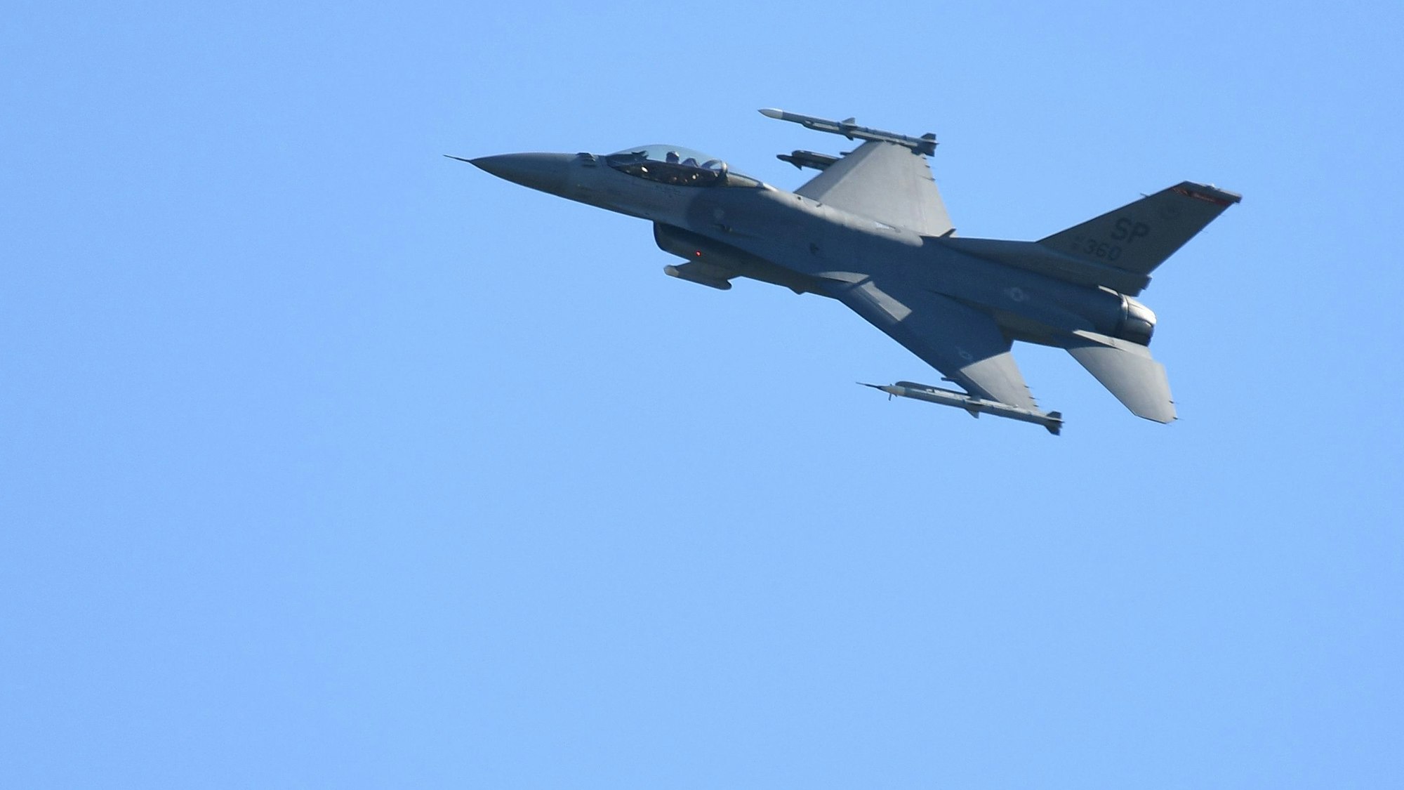 Ein Kampfflugzeug vom Typ F-16 überfliegt die Start- und Landebahn eines US-Militärflughafens.