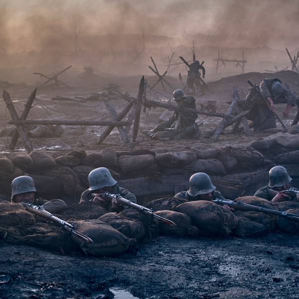 Eine Filmszene: Soldaten liegen mit angelegten Gewehren in einem Schützengraben.