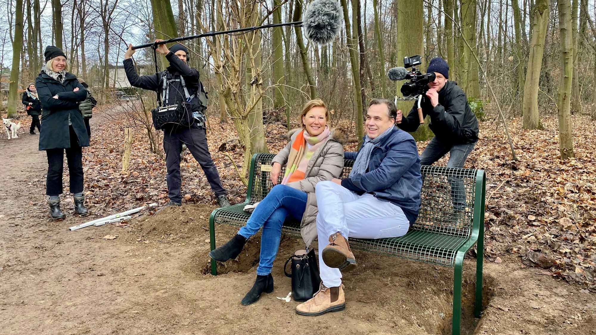 Zwei Menschen sitzen auf der neuen Bank.