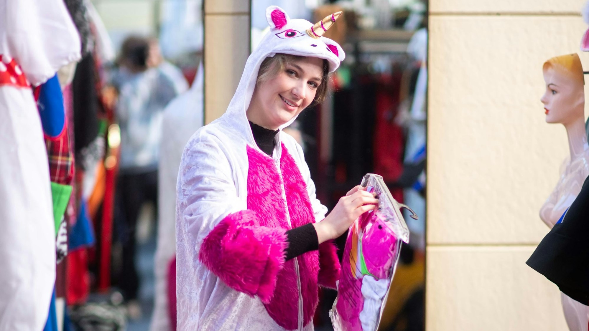 Elena Pintus trägt ein Ganzkörper-Einhornkostüm in pinken und weißen Farben.