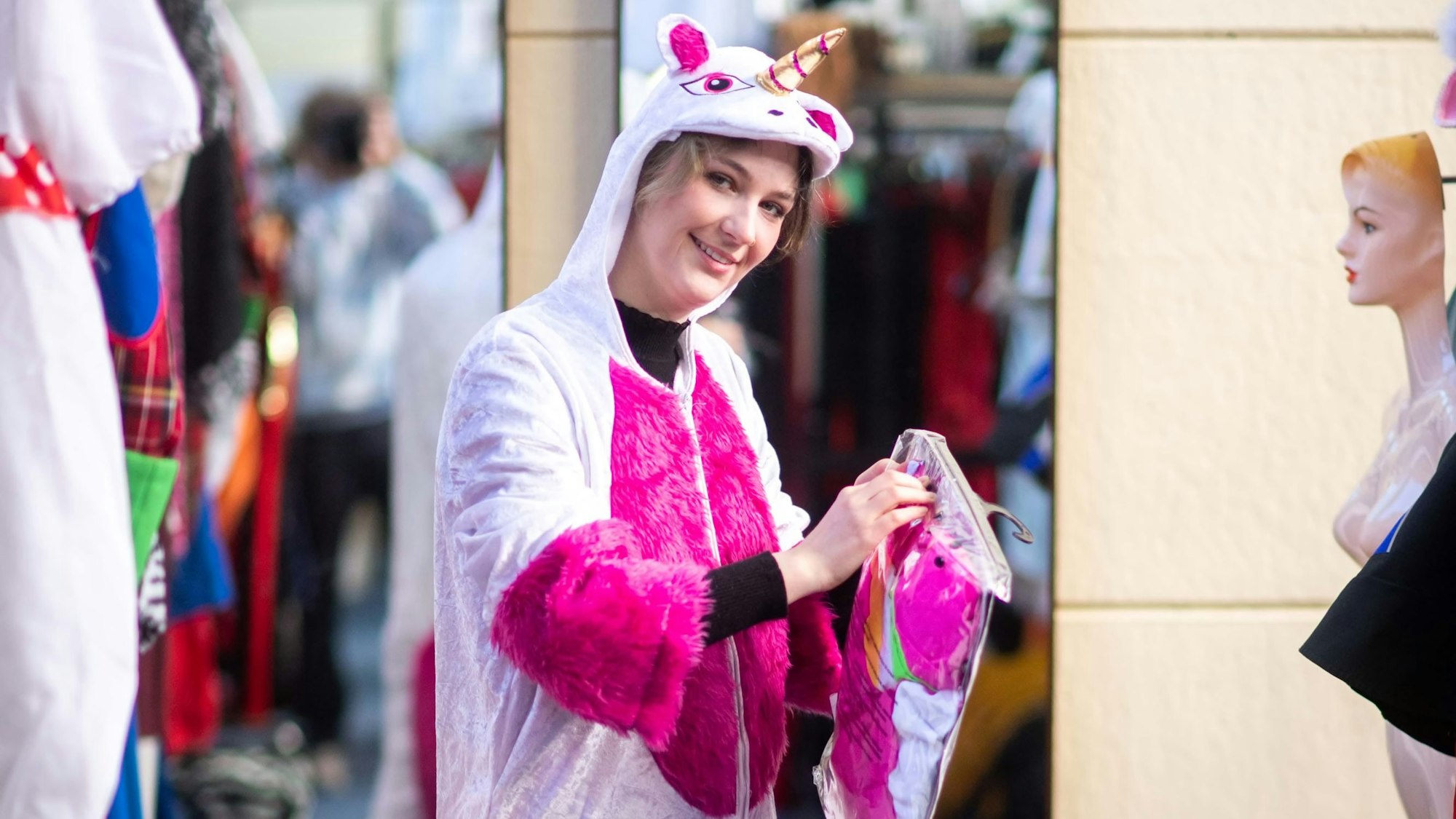 Elena Pintus trägt ein Ganzkörper-Einhornkostüm in pinken und weißen Farben.