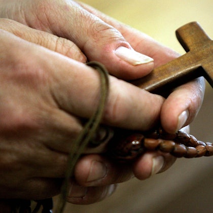 Ein Mann hält einen Rosenkranz in den Händen. (Symbolbild)