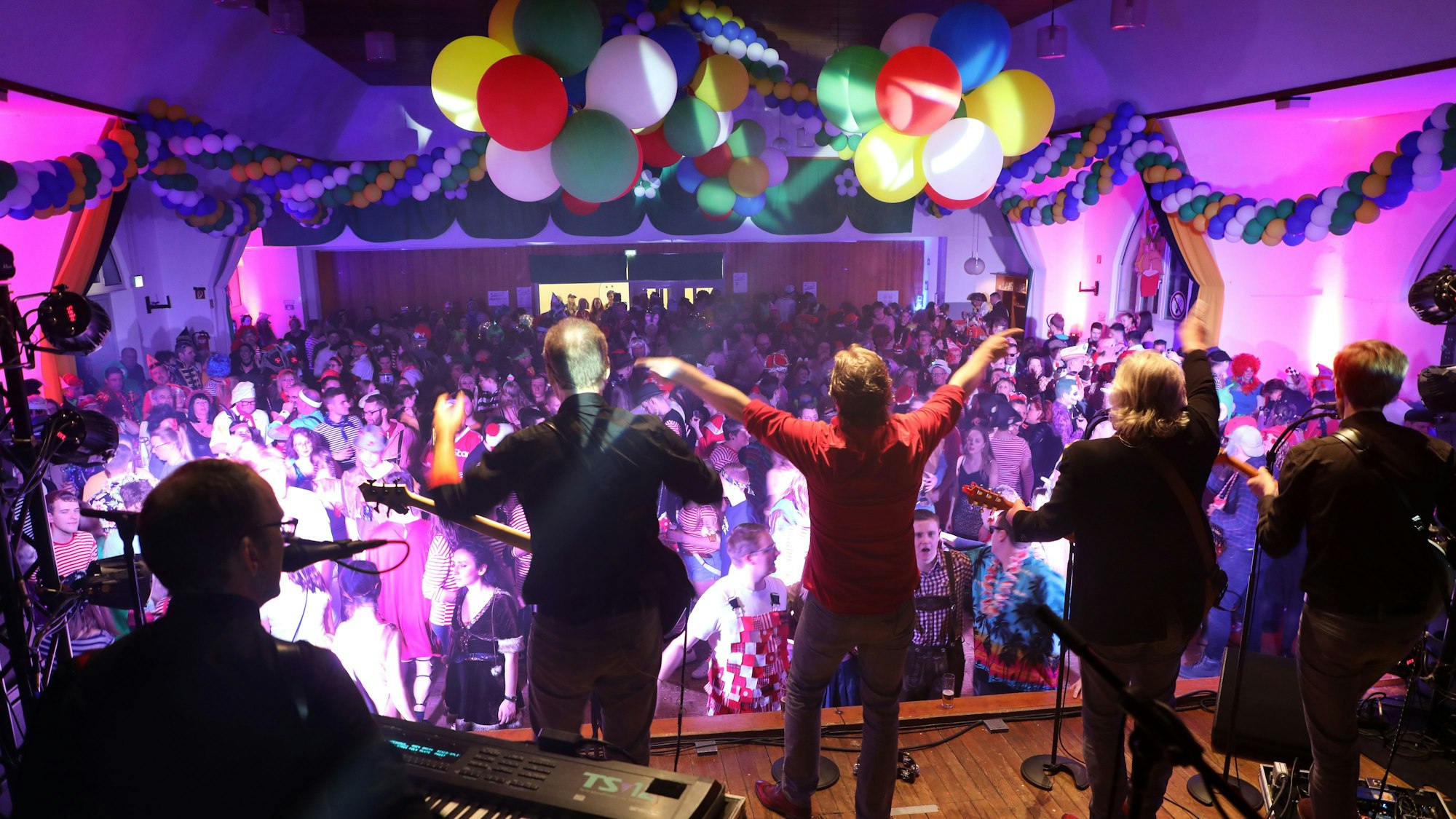 Eine Karnevalsband steht auf einer Bühne und heizt das Publikum an.