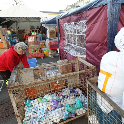 Eine Ehrenamtlerin sortiert Sachspenden.