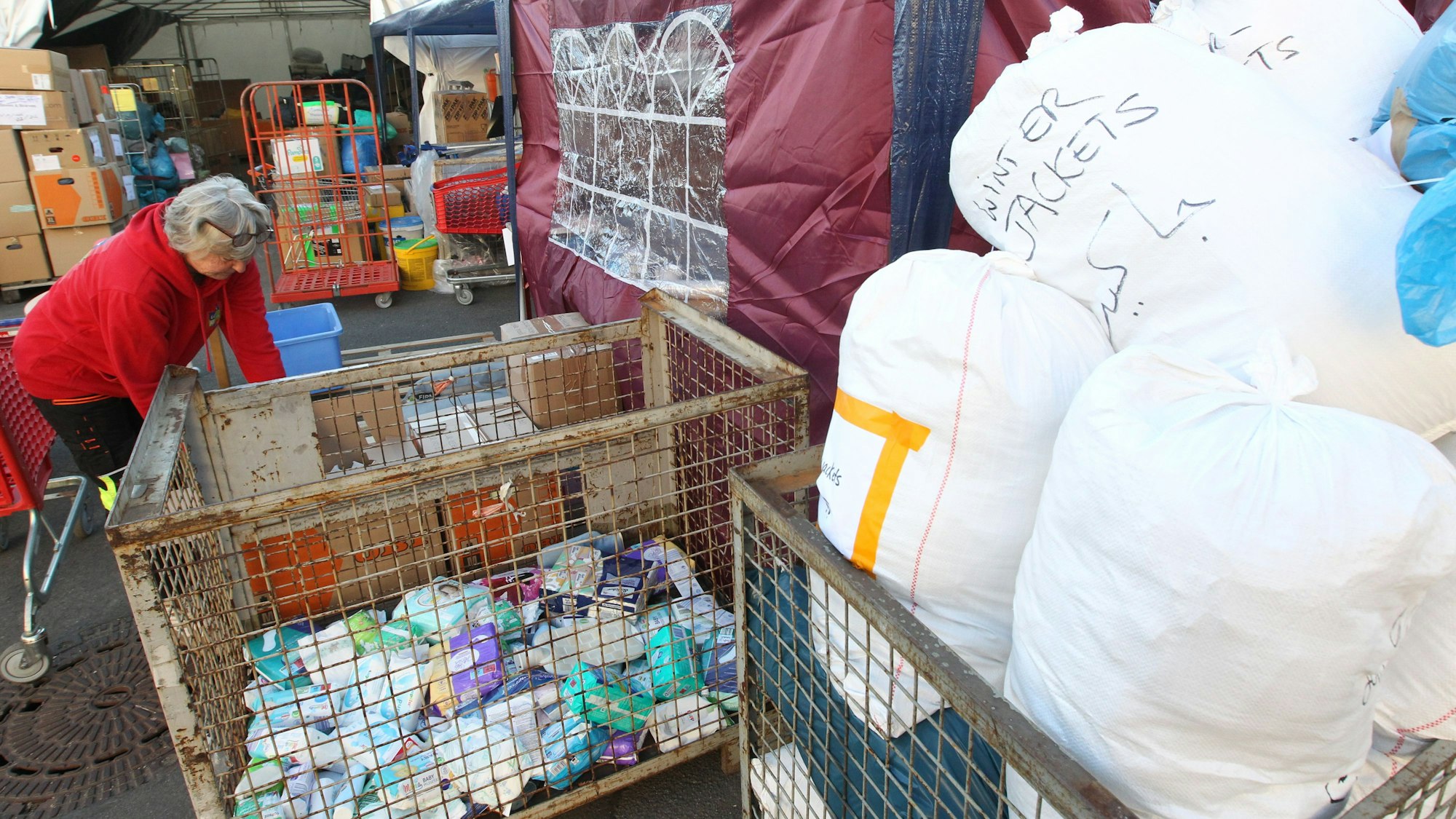 Eine Ehrenamtlerin sortiert Sachspenden.