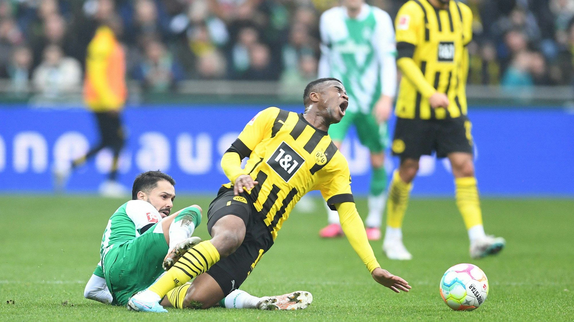 Dortmunds Youssoufa Moukoko (r) wird von Werders Leonardo Bittencourt gefoult.