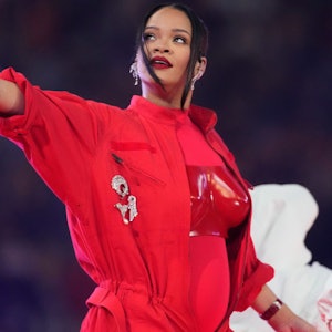 Rihanna tritt während der Halbzeitshow des Super Bowl im State Farm Stadium in Glendale, Arizona auf. Sie trägt einen hellroten Anzug mit dunkelroter Brustplatte.