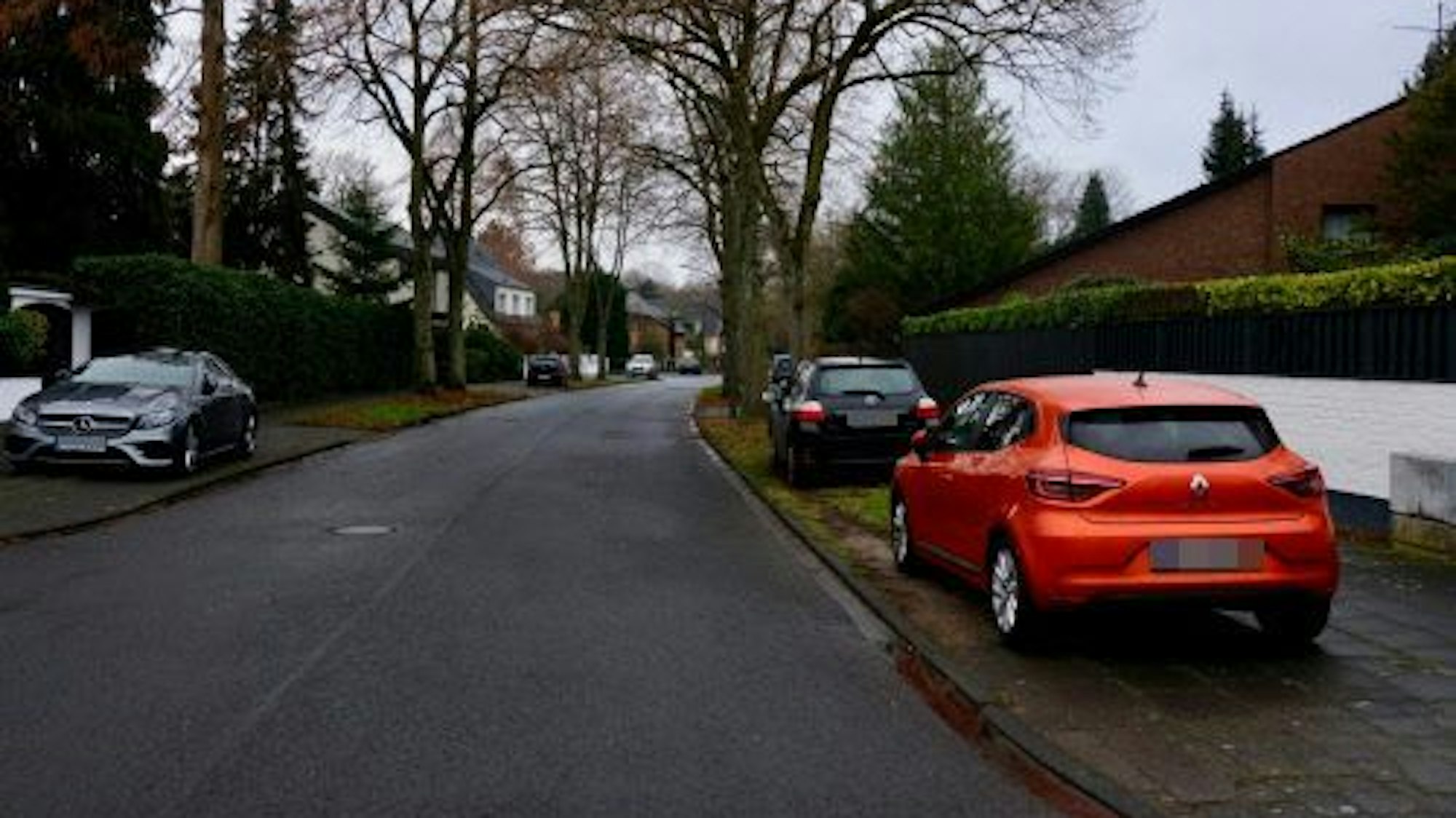 Mehrere Fahrzeuge parken auf dem Grünstreifen Am Gleueler Bach.