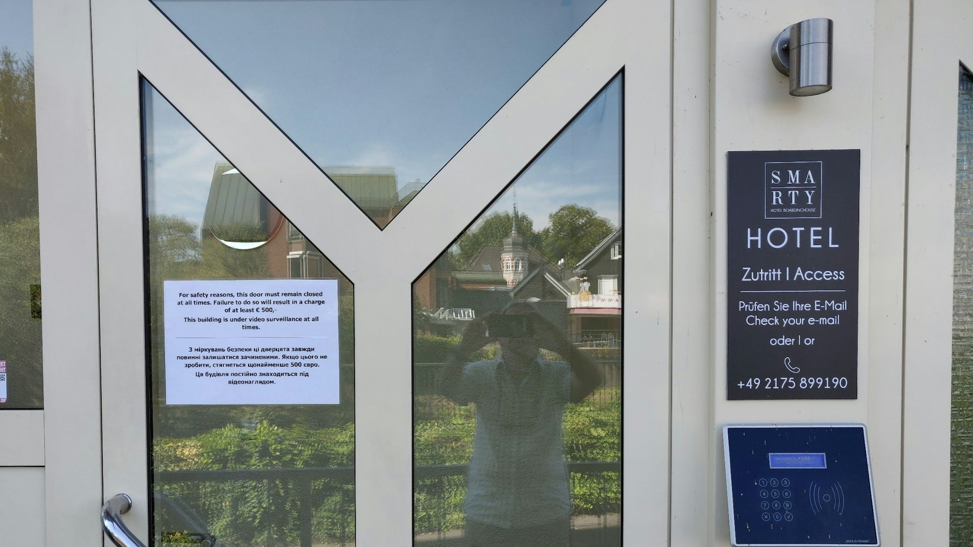 Eingangstüre des Smarty-Hotels mit zweisprachigem Aushang.
