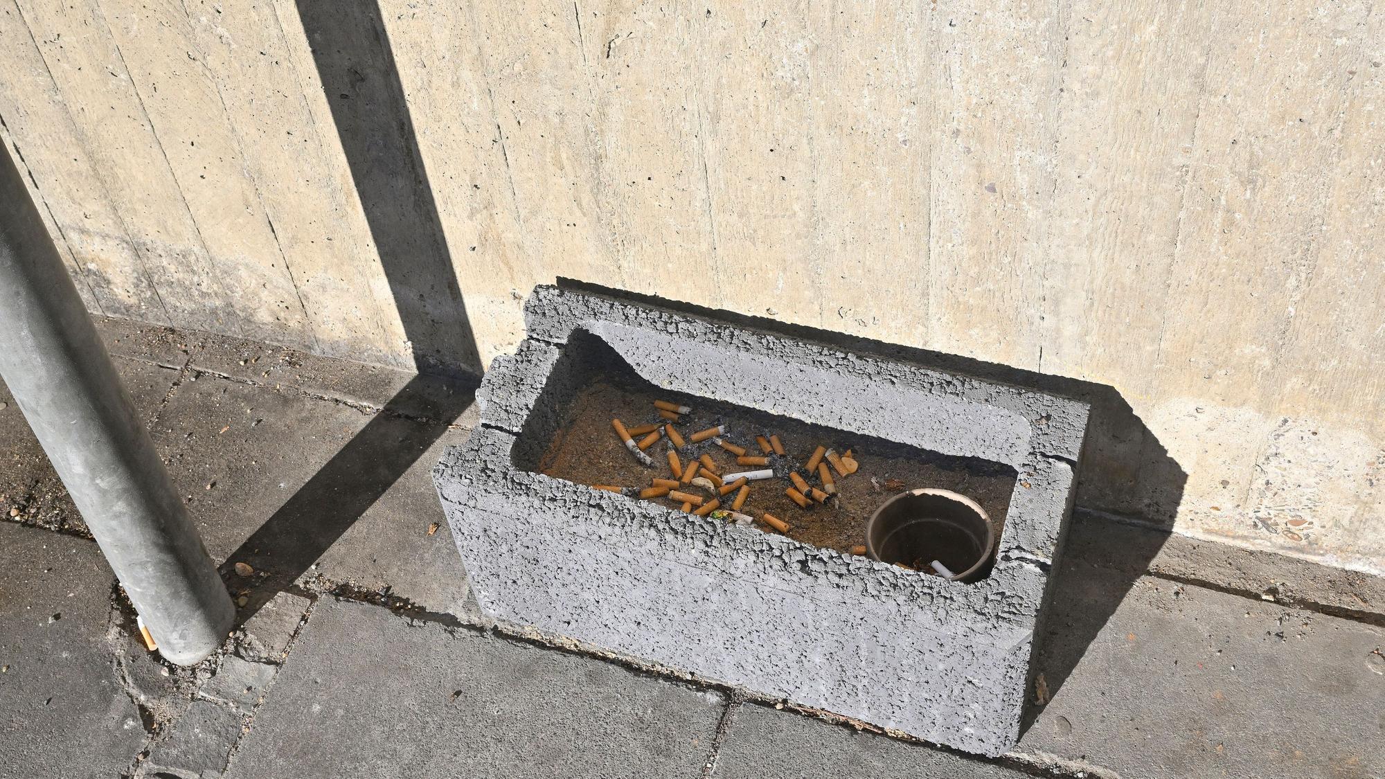 Ein Pflanzstein voll mit Zigarettenkippen.